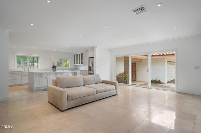 living area with light tile patterned flooring, ornamental molding, and recessed lighting