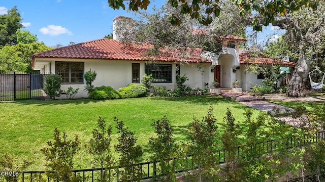 view of front of property with stucco siding, a tile roof, and a chimney