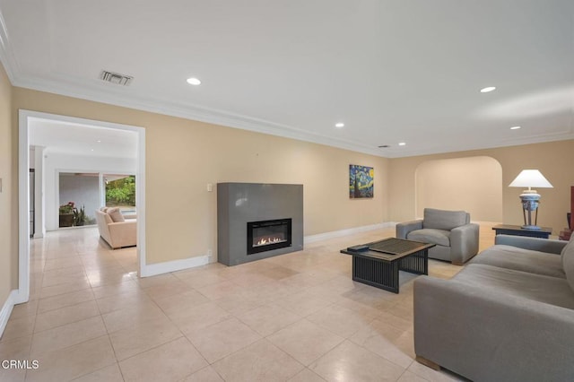 living room featuring baseboards, ornamental molding, a glass covered fireplace, recessed lighting, and arched walkways