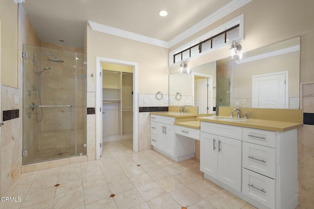 full bathroom with a stall shower, ornamental molding, a walk in closet, and vanity