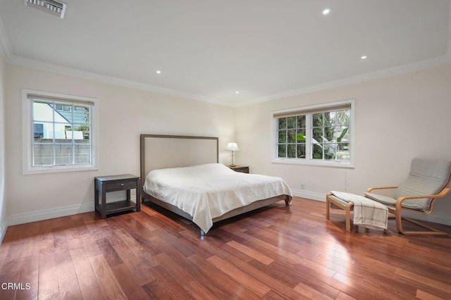 bedroom with baseboards, wood finished floors, crown molding, and recessed lighting