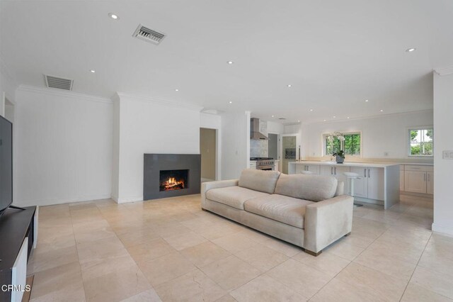 1525 Waverly Rd, San Marino, CA 91108 - living area with crown molding, a warm lit fireplace, recessed lighting, and light tile patterned floors