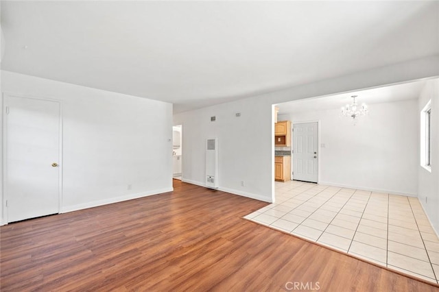 2613 Millbrae Ave, Duarte, CA 91010 - unfurnished living room with a chandelier, light wood-style flooring, and baseboards