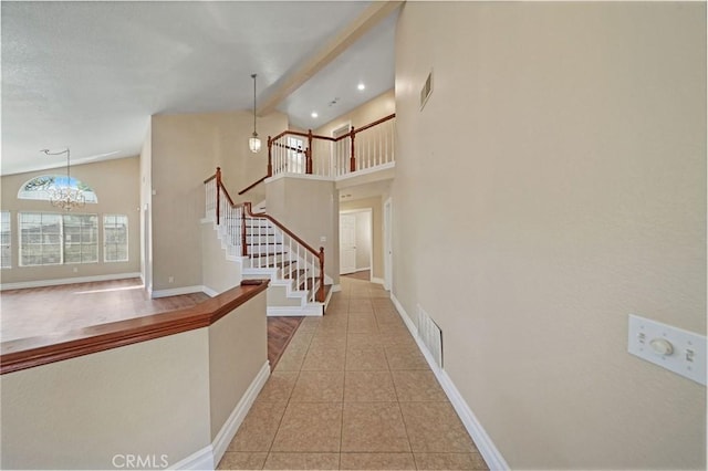 10059 Rock Hl, Moreno Valley, CA 92557 - hallway featuring vaulted ceiling, stairway, a chandelier, tile patterned floors, and baseboards