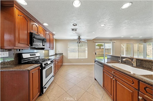 10059 Rock Hl, Moreno Valley, CA 92557 - kitchen with stainless steel appliances, a sink, a ceiling fan, light tile patterned floors, and baseboards