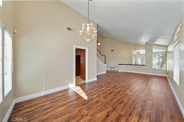 10059 Rock Hl, Moreno Valley, CA 92557 - unfurnished living room featuring dark wood-style flooring, healthy amount of natural light, a chandelier, baseboards, and high vaulted ceiling