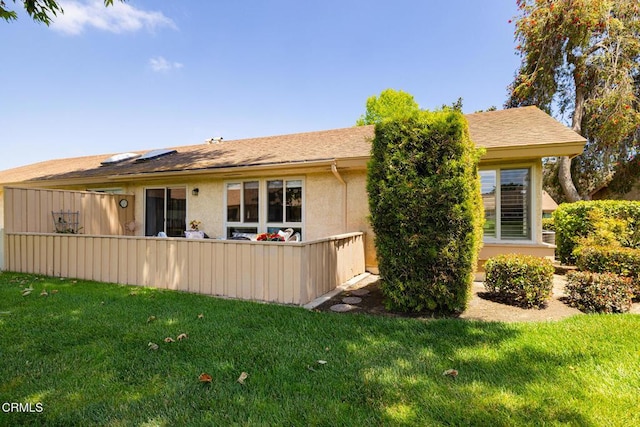 rear view of house featuring stucco siding