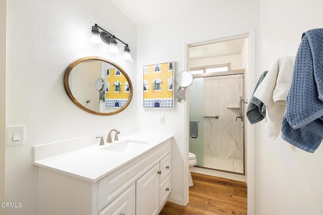 full bathroom with wood finished floors, toilet, a stall shower, and vanity