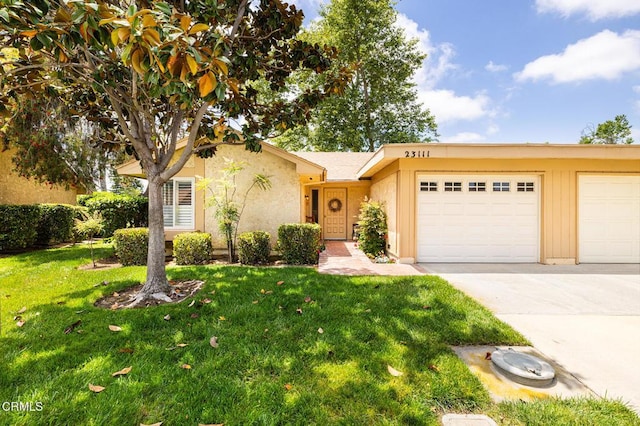 view of front facade with driveway, an attached garage, a front lawn, and stucco siding