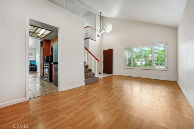 4176 Canyonside Cir, Jurupa Valley, CA 92509 - unfurnished living room with vaulted ceiling, stairs, light wood-style flooring, and baseboards