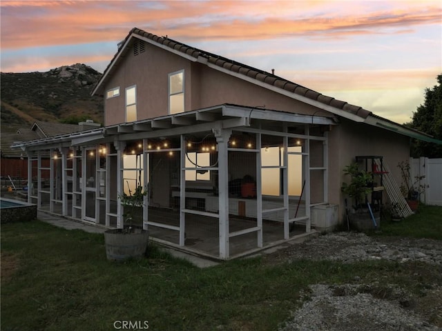 4176 Canyonside Cir, Jurupa Valley, CA 92509 - rear view of house featuring a sunroom, a tile roof, a mountain view, and stucco siding