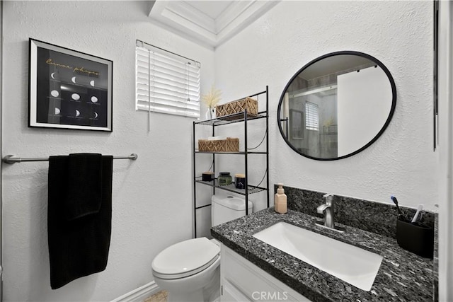 full bathroom featuring toilet, vanity, an enclosed shower, and a textured wall