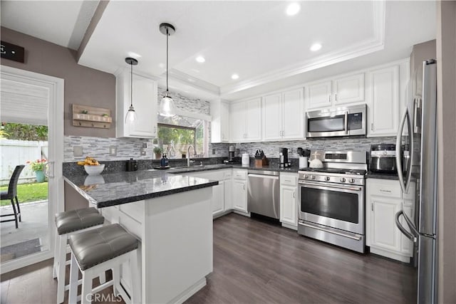1992 Moonbeam Cir, Upland, CA 91784 - kitchen with stainless steel appliances, a tray ceiling, white cabinets, a peninsula, and recessed lighting
