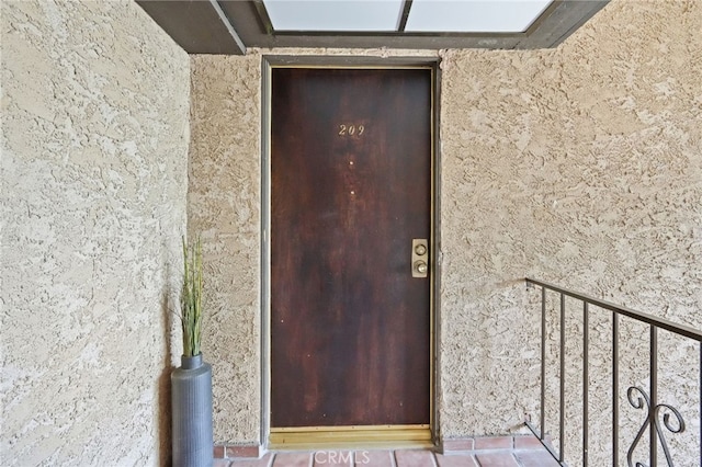 doorway to property featuring stucco siding