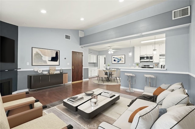 living area featuring wood finished floors, ceiling fan, recessed lighting, vaulted ceiling, and baseboards
