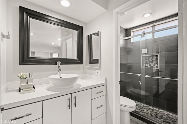 bathroom with a stall shower, vanity, and toilet