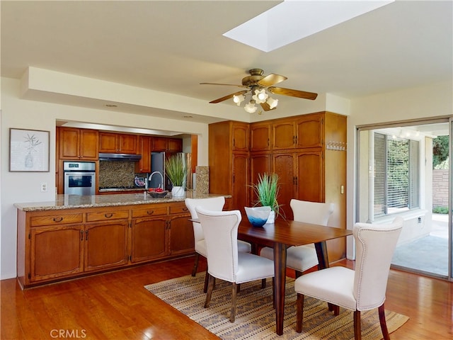 10531 Angel Ave, Fountain Valley, CA 92708 - dining space with wood finished floors, a ceiling fan, a skylight, and baseboards