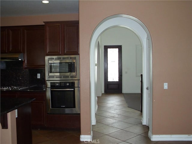 1110 Laurelhurst, San Jacinto, CA 92582 - kitchen featuring appliances with stainless steel finishes, light tile patterned floors, arched walkways, dark countertops, and recessed lighting
