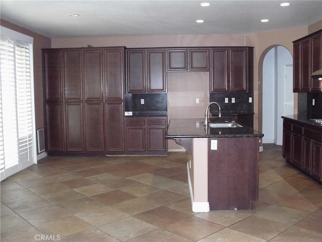 1110 Laurelhurst, San Jacinto, CA 92582 - kitchen with arched walkways, backsplash, recessed lighting, a sink, and dark stone counters
