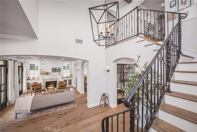 717 35th St, Manhattan Beach, CA 90266 - stairway with wood finished floors, arched walkways, a chandelier, a warm lit fireplace, and baseboards