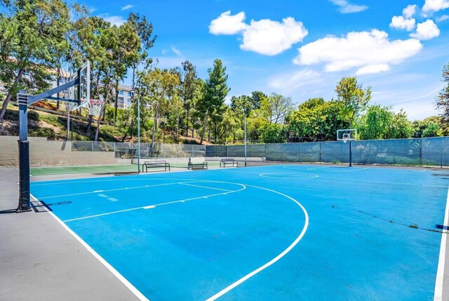 view of basketball court with community basketball court, fence, and a tennis court