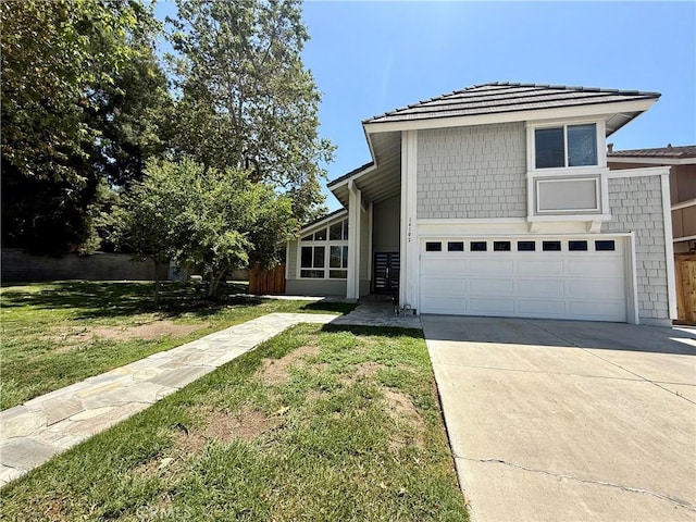 view of front of property with concrete driveway, a front lawn, and a garage