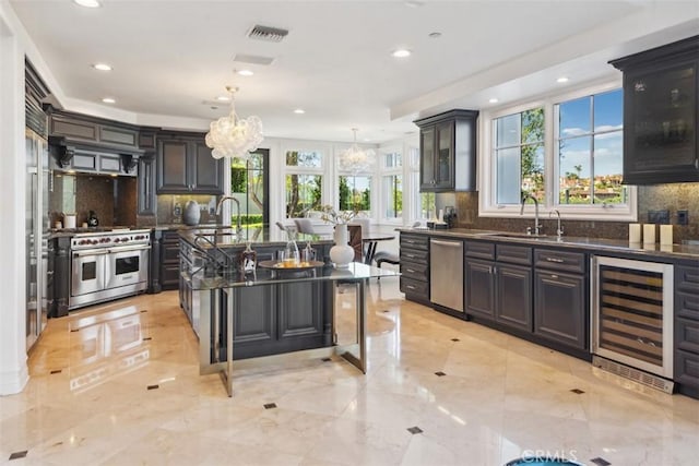 28 Shoreridge, Newport Coast, CA 92657 - kitchen with beverage cooler, appliances with stainless steel finishes, a chandelier, backsplash, and recessed lighting
