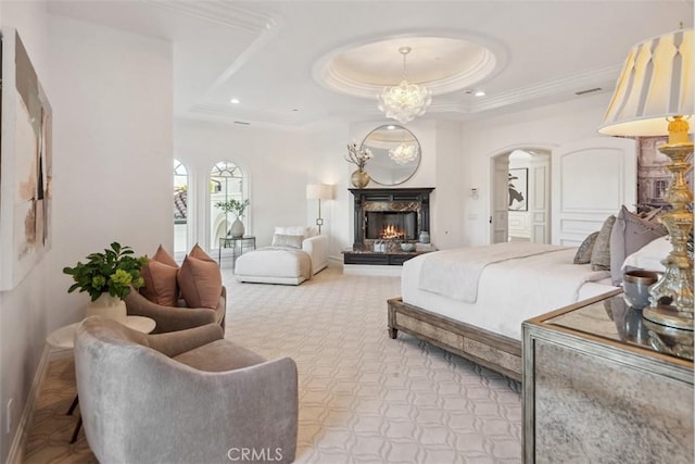 28 Shoreridge, Newport Coast, CA 92657 - bedroom with arched walkways, a warm lit fireplace, a tray ceiling, crown molding, and carpet floors