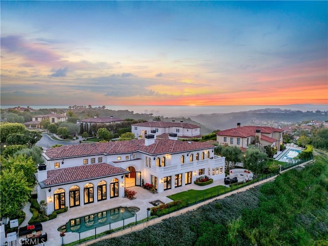28 Shoreridge, Newport Coast, CA 92657 - rear view of house with driveway, a balcony, stucco siding, a fenced backyard, and an outdoor pool