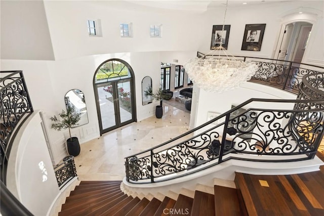 28 Shoreridge, Newport Coast, CA 92657 - foyer featuring french doors, a high ceiling, arched walkways, a chandelier, and ornamental molding