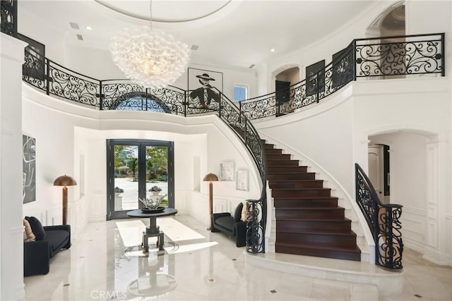 28 Shoreridge, Newport Coast, CA 92657 - entryway featuring a decorative wall, a chandelier, stairs, a high ceiling, and french doors