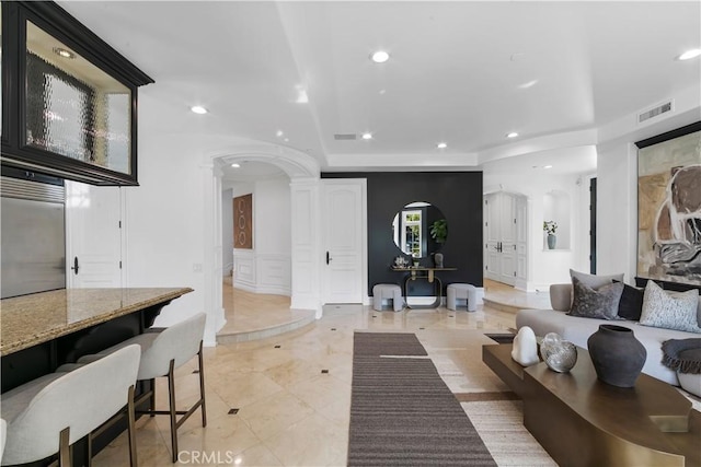 28 Shoreridge, Newport Coast, CA 92657 - living room featuring a decorative wall, decorative columns, recessed lighting, arched walkways, and wainscoting