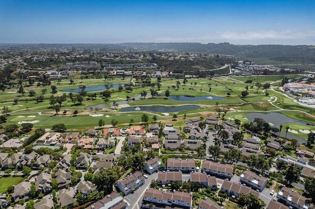 aerial view of property's location featuring a large body of water, nearby suburban area, and a golf course