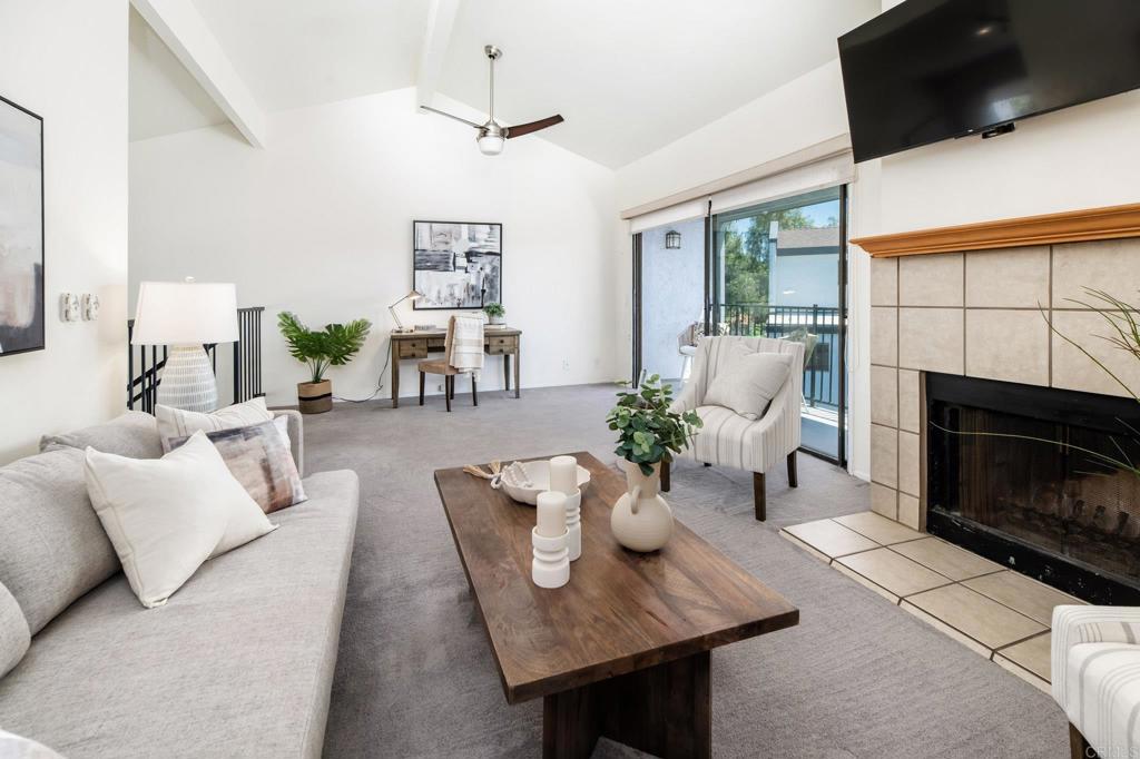 7321 Alicante Rd Unit A, Carlsbad, CA 92009 - carpeted living area featuring a tiled fireplace