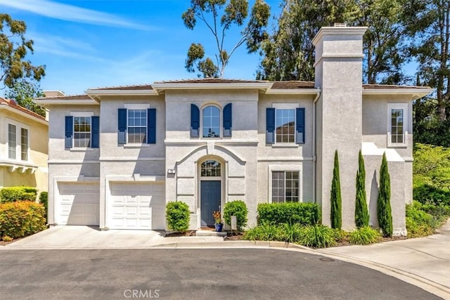 73 Melrose Dr, Mission Viejo, CA 92692 - view of front facade featuring a chimney, driveway, stucco siding, and an attached garage