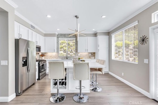 73 Melrose Dr, Mission Viejo, CA 92692 - kitchen with appliances with stainless steel finishes, light countertops, a center island, decorative backsplash, and ornamental molding