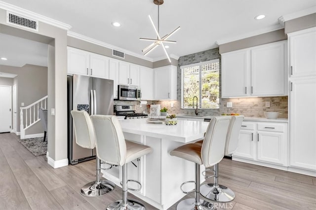 73 Melrose Dr, Mission Viejo, CA 92692 - kitchen with stainless steel appliances, white cabinets, light countertops, a kitchen island, and recessed lighting