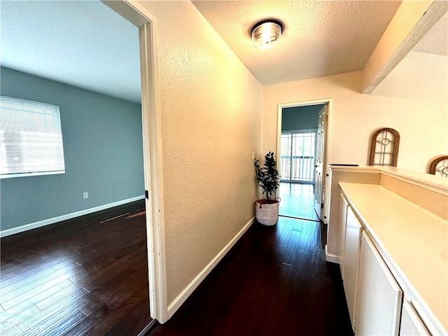 1512 W Sunnyview Dr, Rialto, CA 92377 - corridor featuring dark wood-style flooring, baseboards, a textured wall, and a textured ceiling