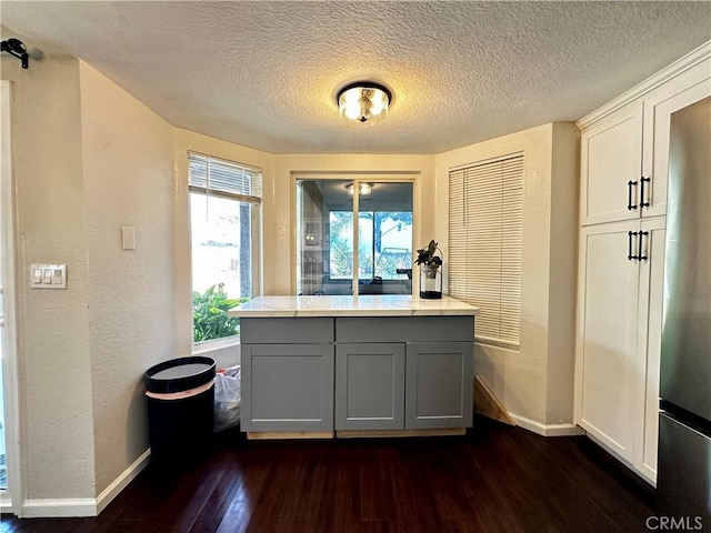 1512 W Sunnyview Dr, Rialto, CA 92377 - kitchen featuring baseboards, dark wood-style floors, gray cabinetry, a textured ceiling, and freestanding refrigerator