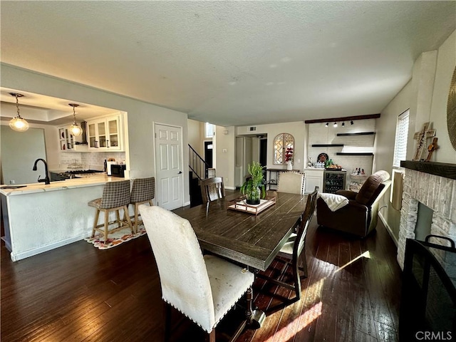 1512 W Sunnyview Dr, Rialto, CA 92377 - dining area featuring dark wood-style flooring, a fireplace, stairs, and baseboards