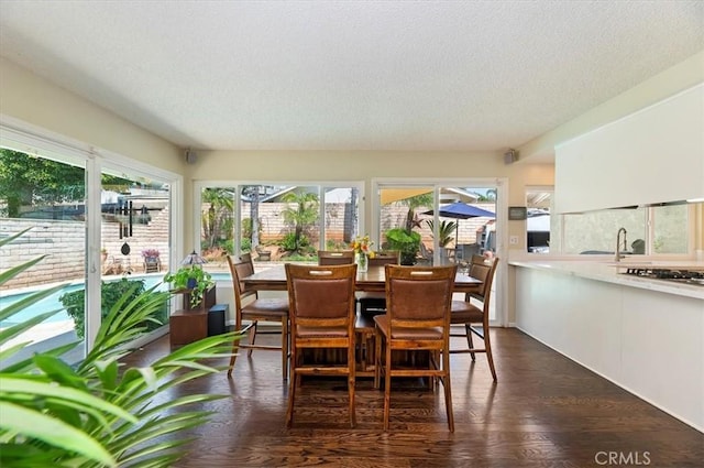 sunroom / solarium featuring a textured ceiling and wood finished floors