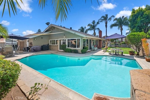 view of pool with a patio and fence