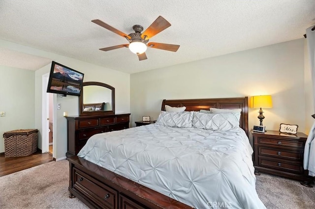carpeted bedroom with a textured ceiling, ceiling fan, and baseboards