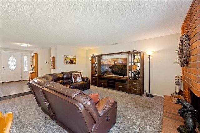living area with a textured ceiling, a brick fireplace, and carpet flooring