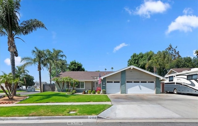 ranch-style home with driveway, an attached garage, and a front lawn