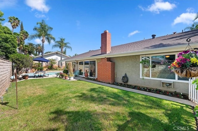 rear view of property featuring stucco siding and a chimney
