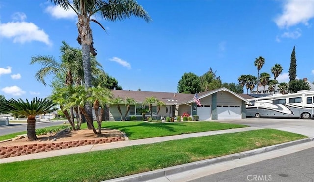 ranch-style house featuring an attached garage, a front yard, and driveway