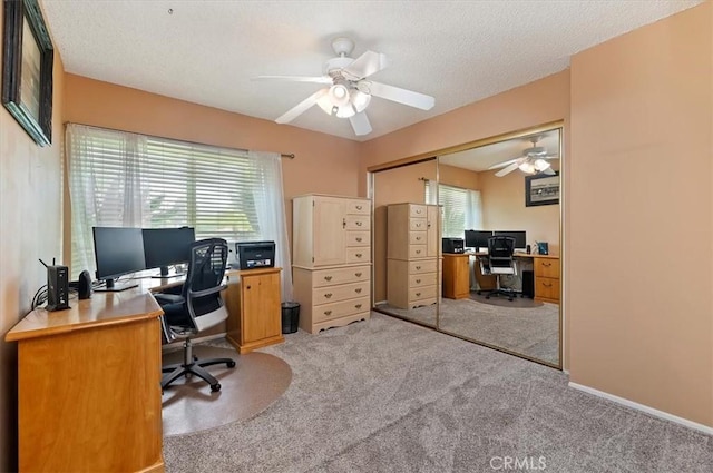 carpeted office with ceiling fan and a textured ceiling