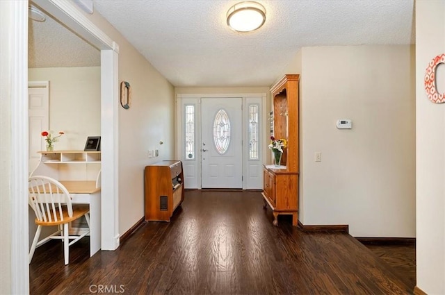 foyer with dark wood-style floors, baseboards, and a textured ceiling