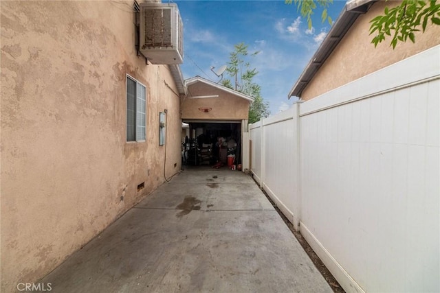 view of home's exterior with fence, stucco siding, and a garage
